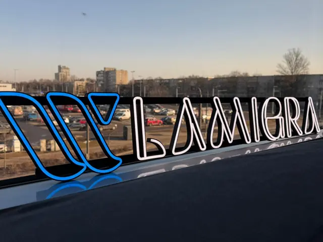 3D spausdintos LED raidės su logotipu ant pastato stogo, mėlyna ir balta šviesa
