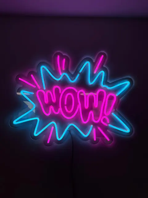Rožinis ir mėlynas LED neoninis užrašas „WOW“ komiksų stiliaus